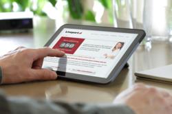 A hotel guest using an iPad in a hotel room.